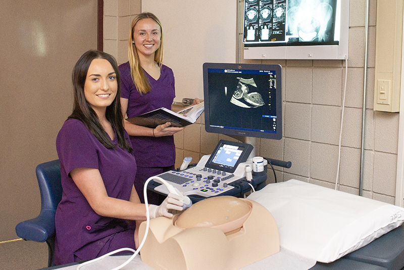 Photo of two lsue students using sonogram on a model